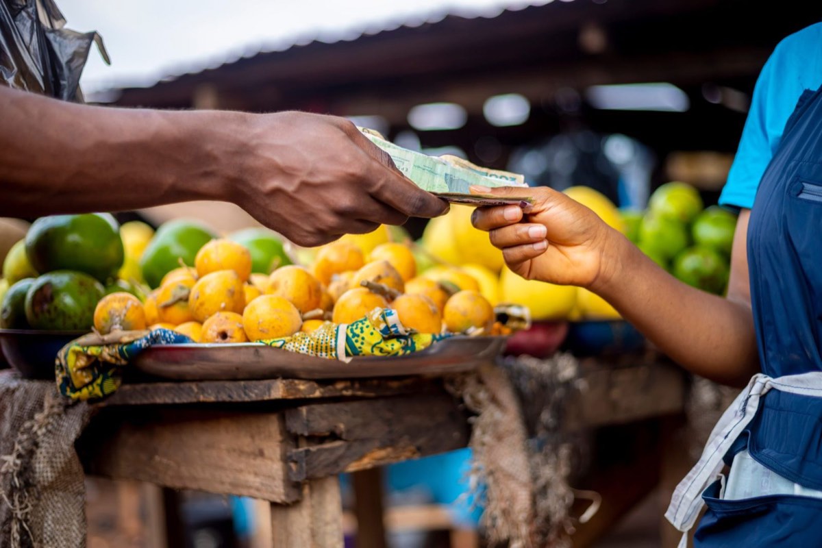 Hand-to-hand payment for fresh produce at a Liberian market
